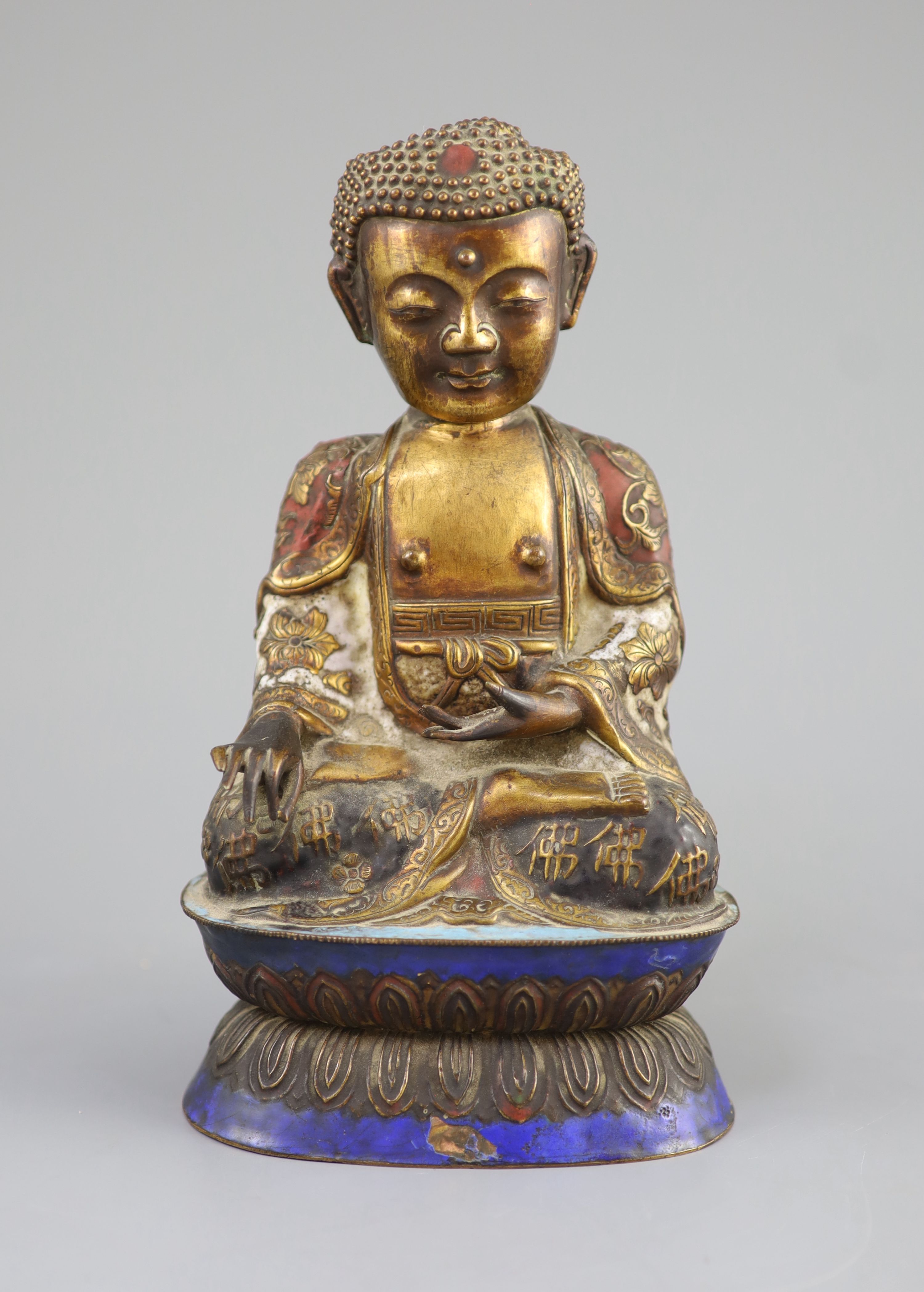A Chinese copper alloy and enamel seated figure of Buddha Shakyamuni, Qing dynasty, 24cm high, faults